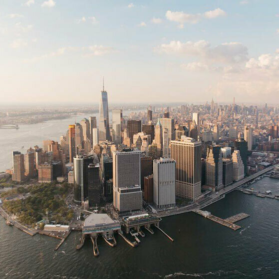 Lower Manhattan skyline with One World Trade Center beside the Hudson River.