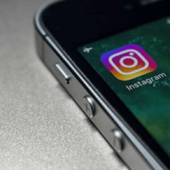 Close-up of a smartphone showing the Instagram app icon and label.