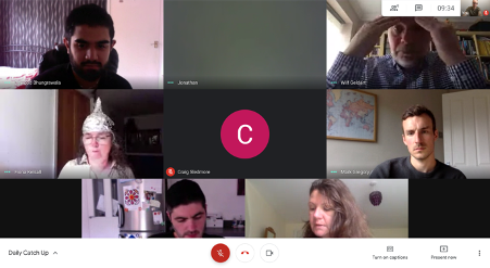 A group of people looking at a screen Description automatically generated