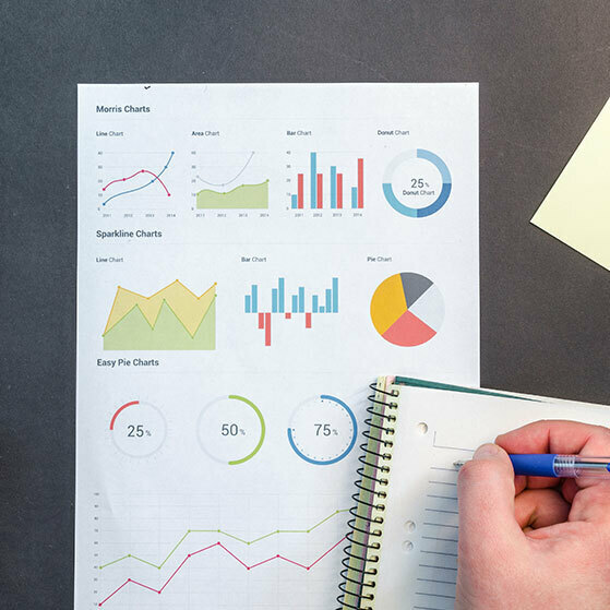 Printed chart dashboard labeled “Morris Charts” with a hand writing in a spiral notebook.