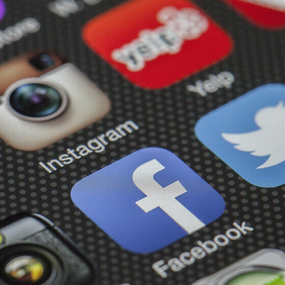Social media app icons on a phone screen, including Instagram, YouTube, Yelp, Twitter and Facebook.