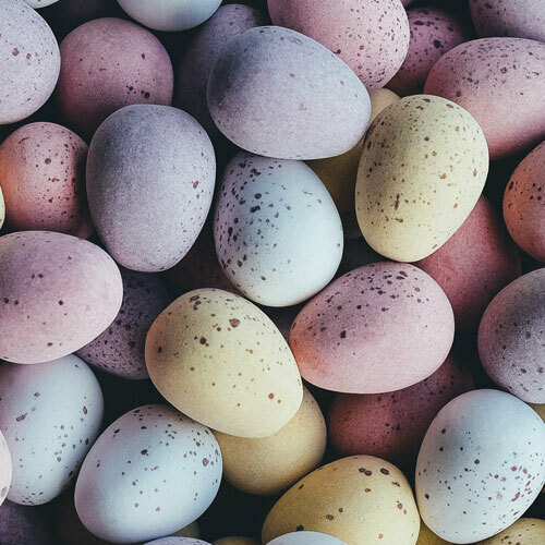 Pastel speckled Easter eggs in pink, blue, yellow, and lavender.