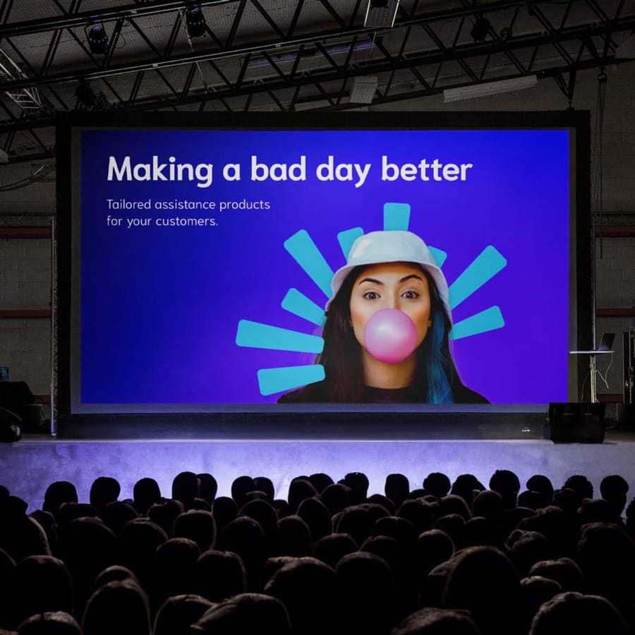 Conference screen reads “Making a bad day better” and “Tailored assistance products for your customers.”