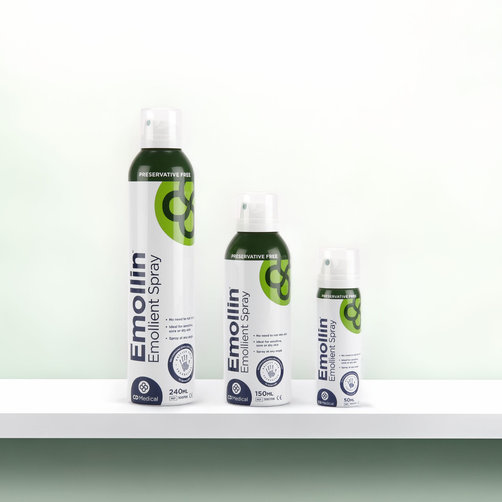 Three sizes of Emollin Emollient Spray bottles labeled preservative free: 240ml, 150ml and 50ml.